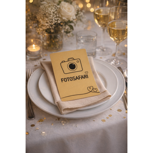 Fotosafarikort med sjove fotoopgaver i sort og guld, placeret p� en tallerken p� et hyggeligt festbord med blomster og levende lys.